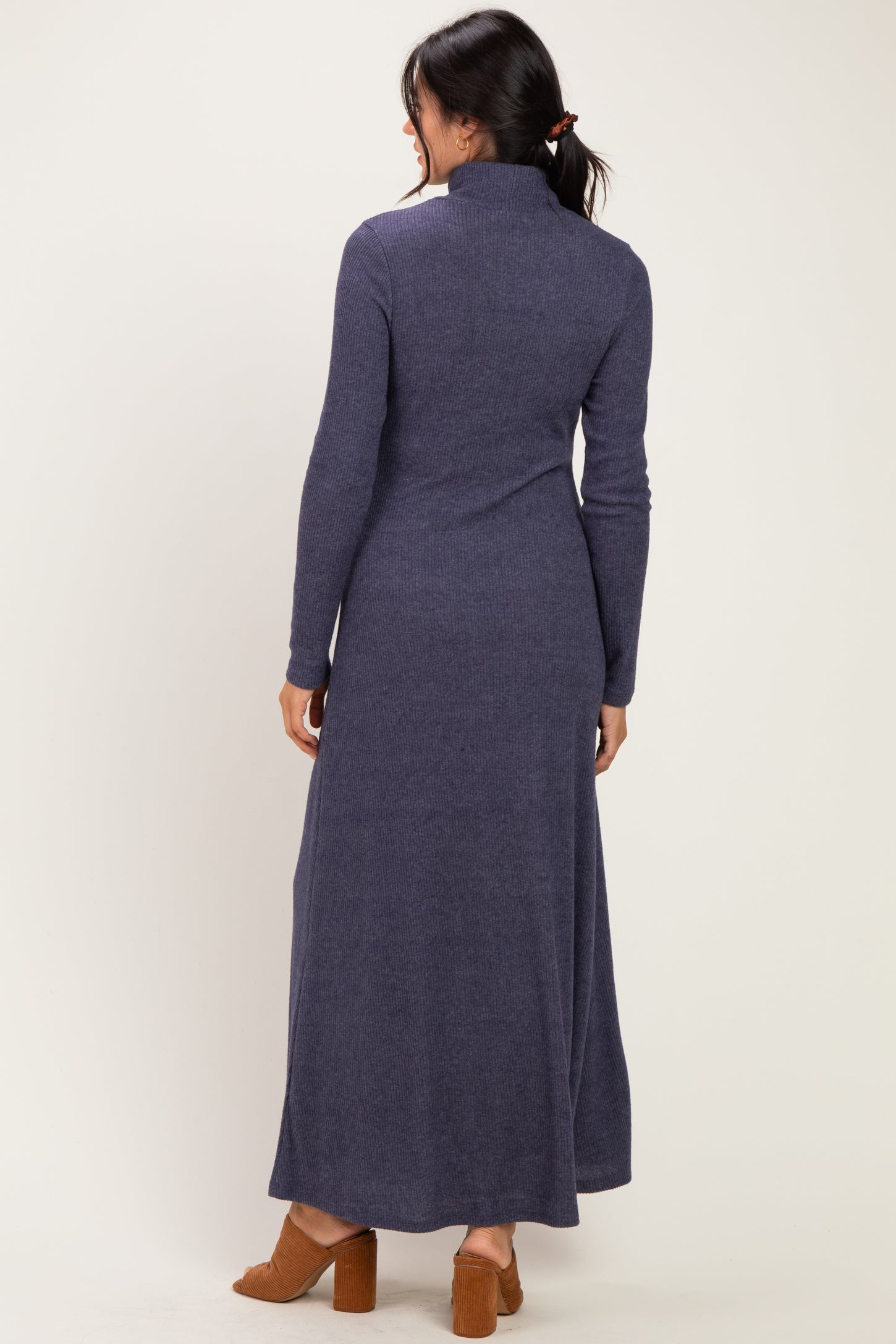 woman wearing a long navy blue turtleneck maxi dress with long sleeves and a fitted silhouette