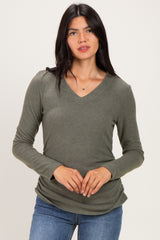 woman wearing an olive green long sleeve v-neck top with a relaxed fit and light knit texture