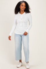 woman wearing a white long sleeve hoodie with buttons and light blue wide leg jeans