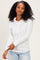woman wearing a white long sleeve henley top with buttons and ruched sides, smiling at the camera