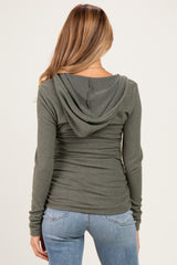 woman wearing a green long sleeve maternity hoodie with a fitted silhouette and hood, turned away from the camera