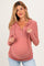 woman wearing a dusty rose maternity hoodie with a button-up front and a visible baby bump