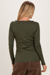 woman wearing a dark green long sleeve ribbed top, shown from the back