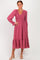 woman wearing a rose-colored long sleeve smocked dress with a tiered skirt and a V-neckline