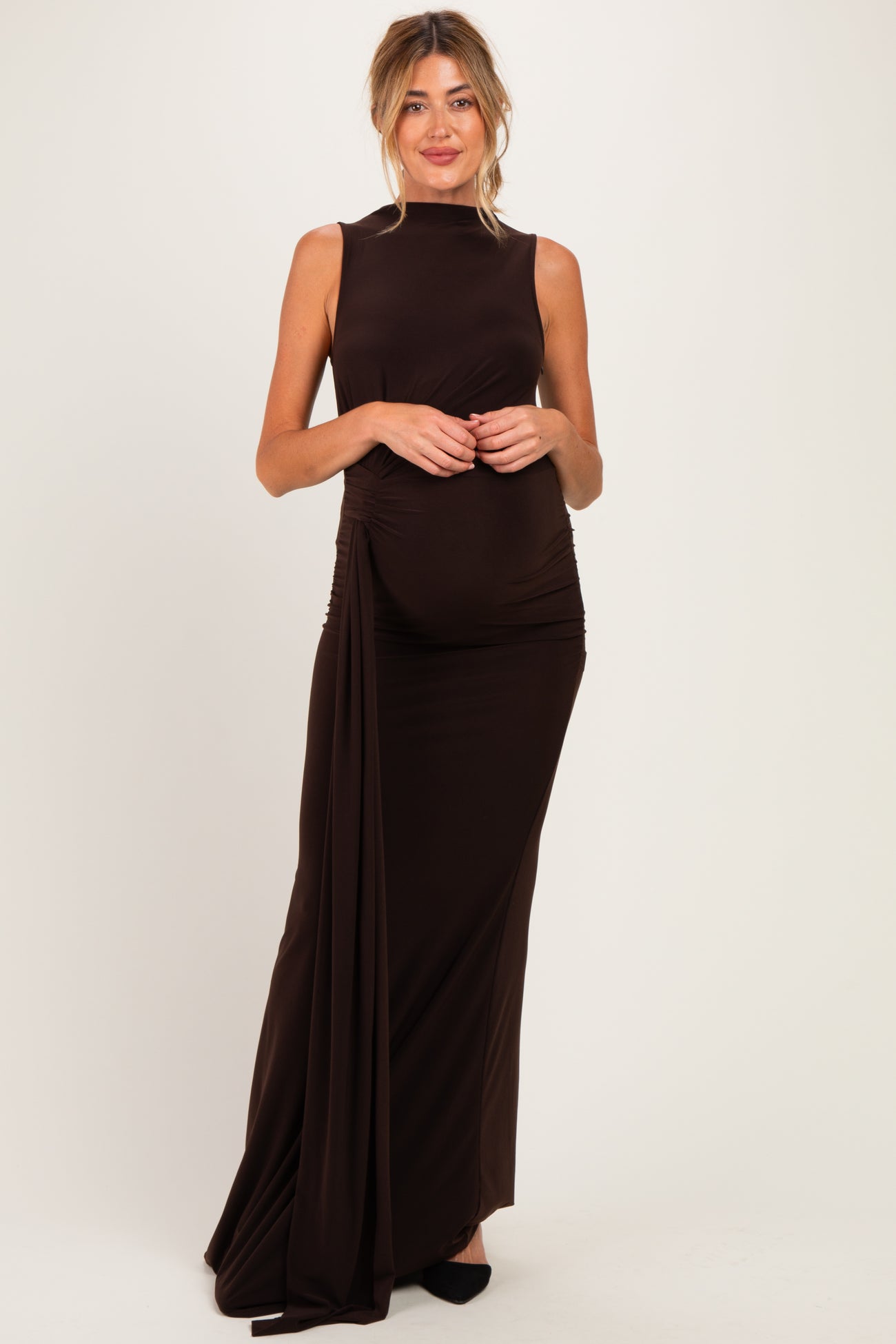 woman wearing a dark brown sleeveless maternity gown with side ruching and a visible baby bump