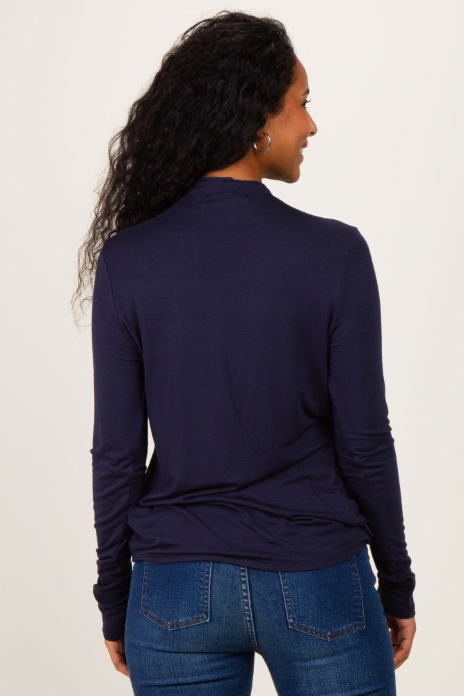 woman wearing a navy long sleeve maternity top, viewed from the back, paired with blue jeans
