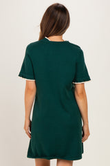woman wearing a dark green maternity dress with short sleeves and a relaxed fit, shown from the back