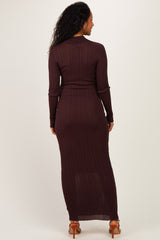 woman wearing a dark brown long sleeve maternity dress with a fitted silhouette and a maxi length, showing her baby bump
