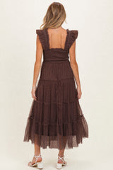 woman wearing a chocolate brown maternity maxi dress with ruffled sleeves and a tiered skirt, showing her back