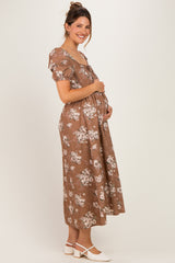 woman wearing a brown floral maternity dress with a flowy silhouette and baby bump visible