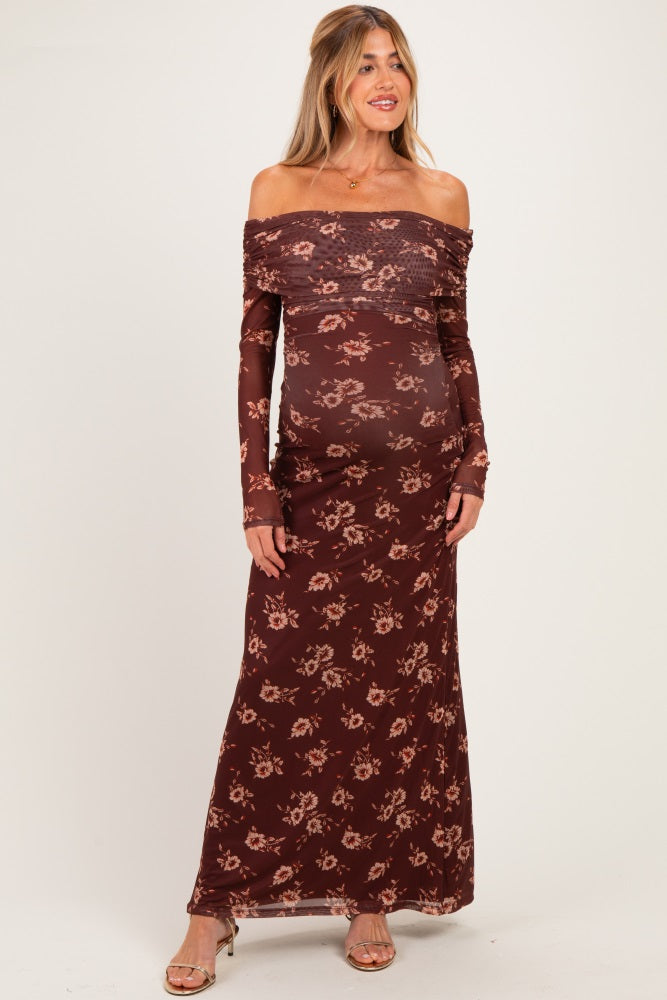 woman wearing a burgundy off-the-shoulder maternity dress with floral print and a visible baby bump