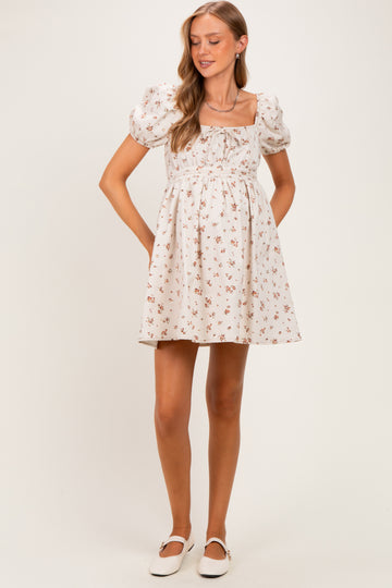 woman wearing a white floral maternity dress with puff sleeves and a square neckline, featuring a baby bump