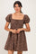 woman wearing a brown floral print dress with a square neckline and puff sleeves