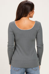 woman wearing a gray long sleeve maternity top with a scoop back design