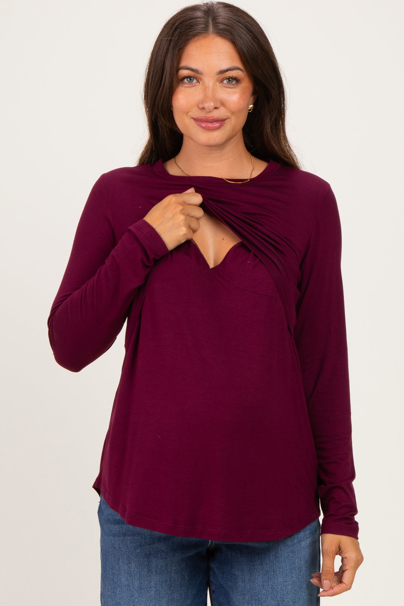 woman wearing a plum long sleeve maternity top with ruched detail for easy nursing access and a visible baby bump