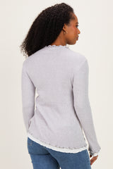 woman wearing a light gray ribbed sweater with frayed edges and back view showing long sleeves and a relaxed fit
