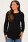 woman wearing a black long sleeve maternity top with a fitted bodice and relaxed hemline, smiling