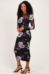 woman wearing a black floral long sleeve midi dress with sheer sleeves and fitted silhouette