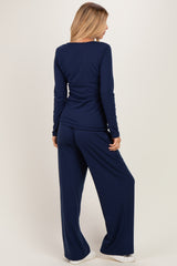 woman wearing a navy long sleeve top and matching wide-leg pants, view from the back