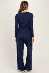 woman wearing a navy blue long sleeve maternity top and matching wide-leg pants, viewed from the back