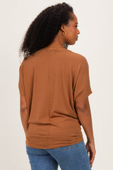 woman wearing a brown short sleeve top with a relaxed fit, styled with blue jeans, seen from the back