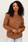 woman wearing a brown textured knit sweater with long sleeves and a relaxed fit