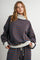 woman wearing a brown and blue striped oversized turtleneck sweatshirt with gray cuffs and matching bottom outfit