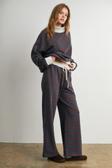woman wearing a striped oversized sweater and matching wide-leg pants with a drawstring waist
