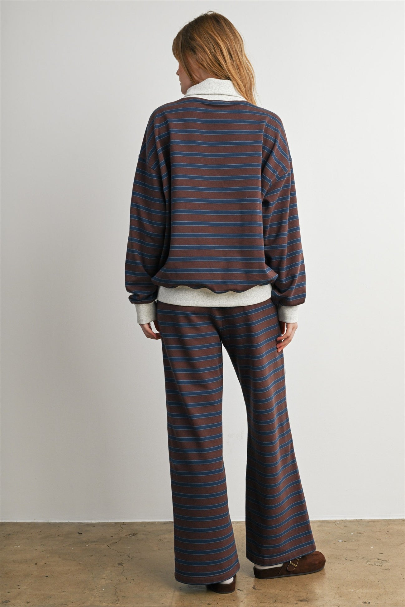 woman wearing a striped oversized sweater with matching wide-leg pants, viewed from the back