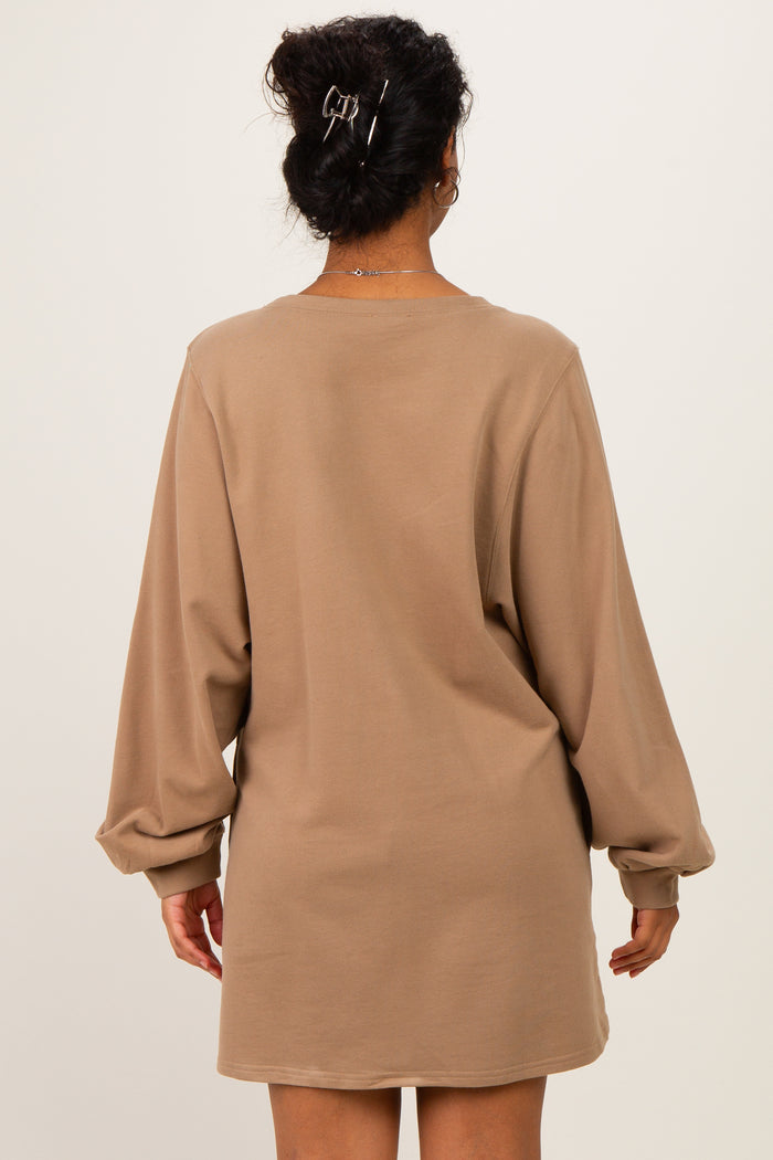woman wearing a beige long sleeve maternity dress, showing a relaxed fit and loose sleeves from the back