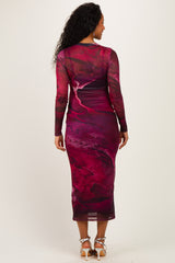woman wearing a form-fitting maroon printed maternity dress with long sleeves, showing a flowing design from the back