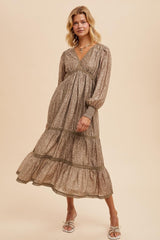 woman wearing a brown floral maxi dress with long sleeves and tiered ruffle hem