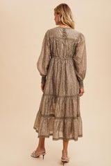 woman wearing a brown floral long sleeve maxi dress with tiered skirt and gathered waist detail