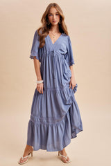 woman wearing a flowy lavender maxi dress with short sleeves and tiered ruffles, styled with strappy sandals