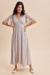 woman wearing a lavender floral maxi dress with flutter sleeves and a deep v-neckline