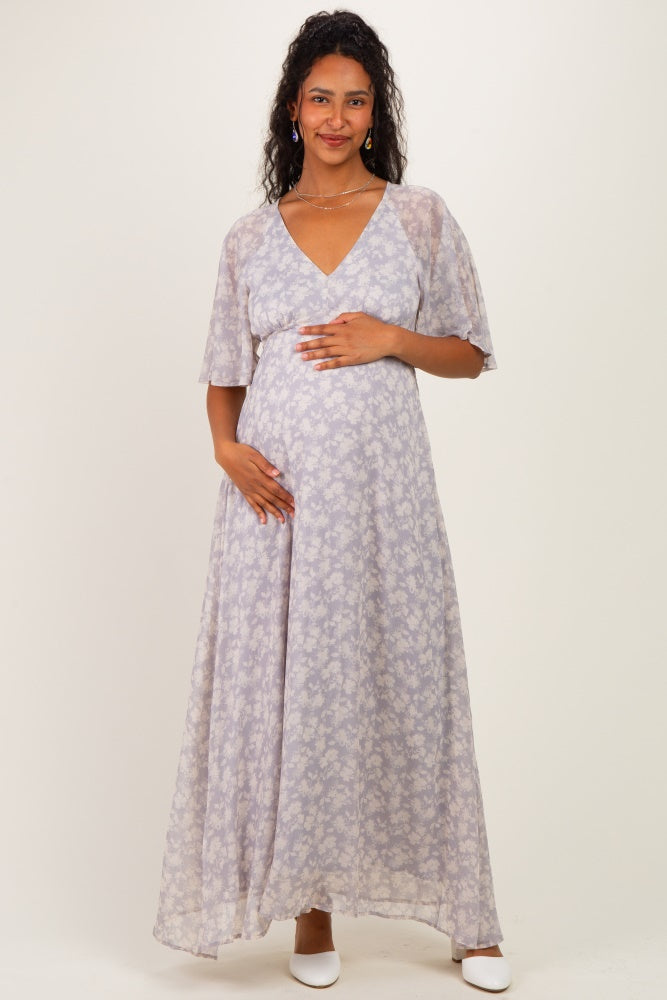 woman wearing a lilac floral maternity maxi dress and holding her baby bump