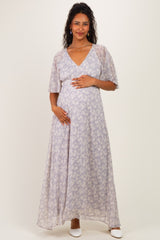 woman wearing a lilac floral maternity maxi dress and holding her baby bump