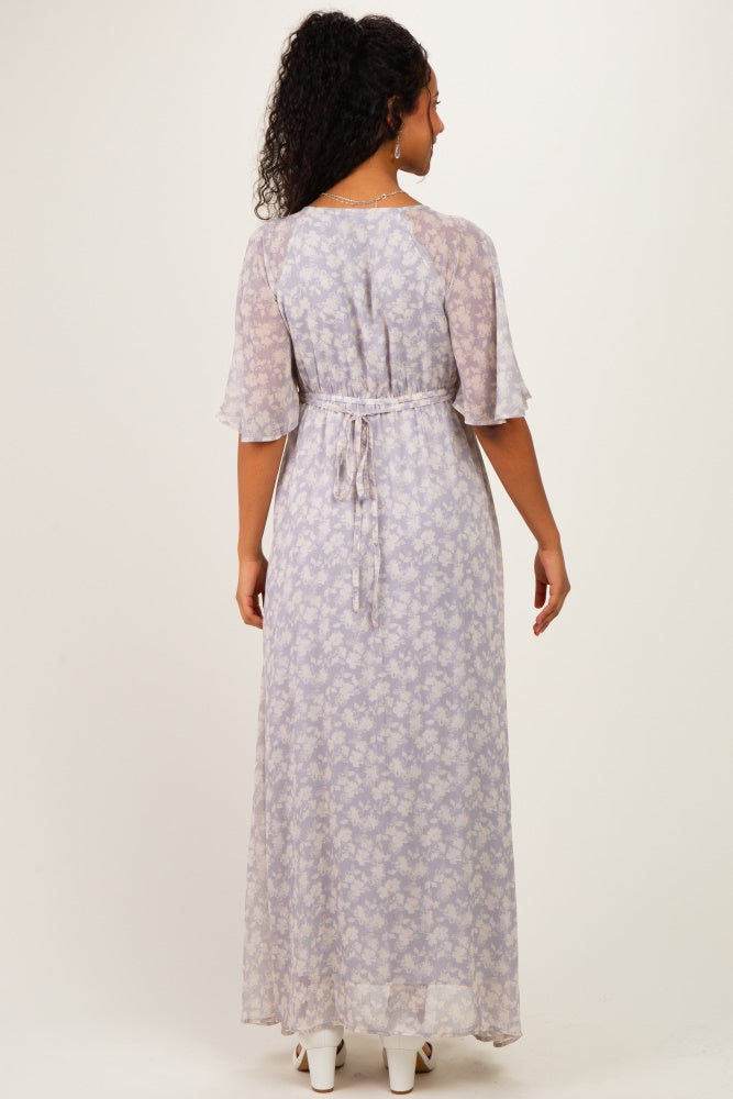 woman wearing a light purple floral maternity maxi dress with short sleeves and a tie waist, showing a baby bump