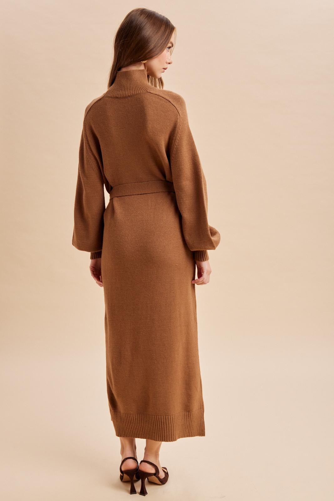 woman wearing a brown long sleeve knitted maxi dress with a belt, showing the back view