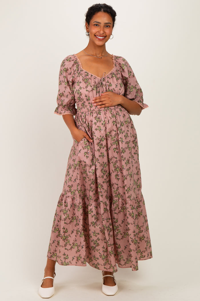 woman wearing a pink floral maternity maxi dress with puff sleeves and holding her baby bump