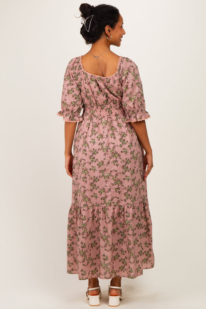 woman wearing a pink floral maternity maxi dress with puff sleeves and a tiered hem, showing a baby bump from the back