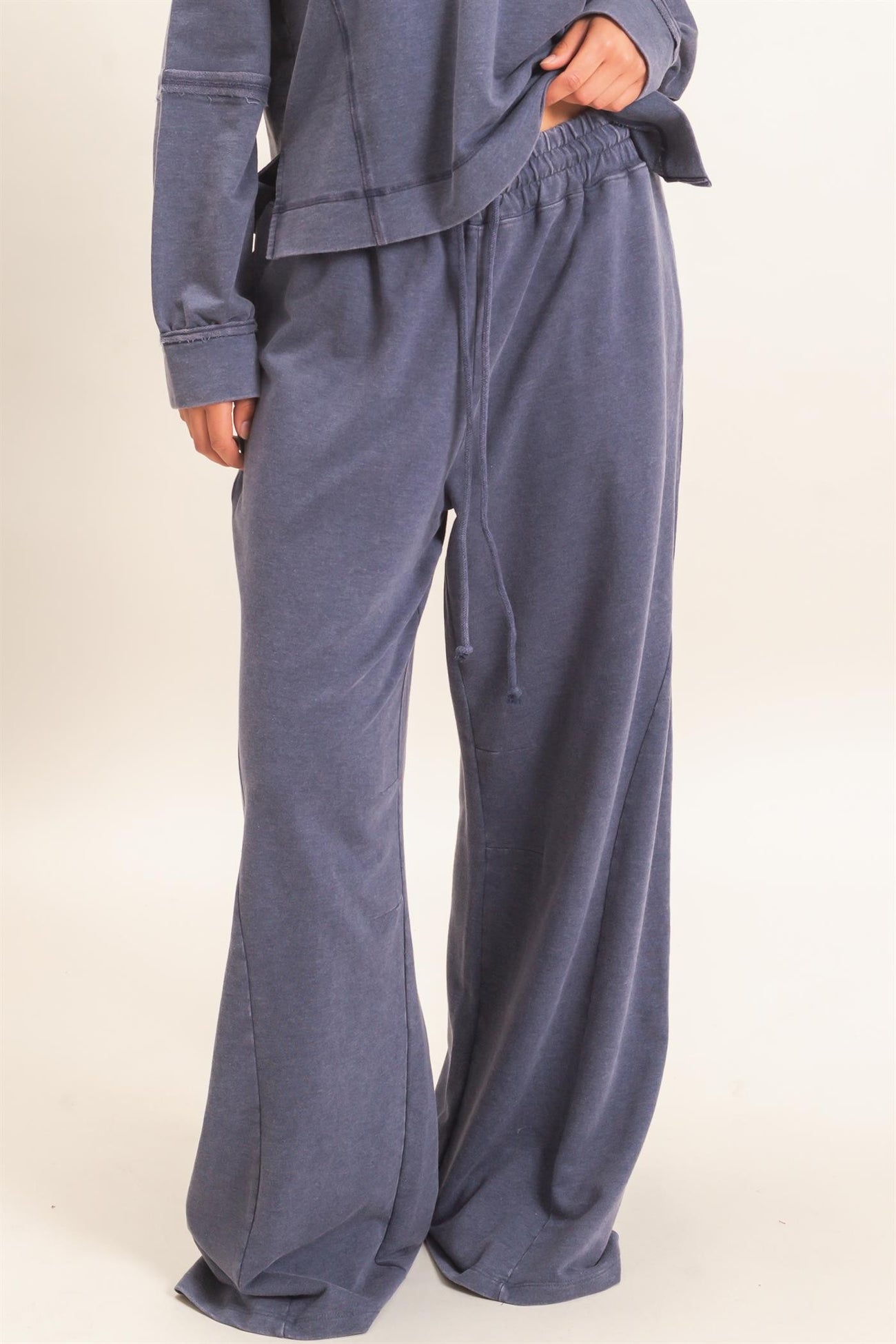 woman wearing navy blue wide leg lounge pants with an elastic waistband and drawstring detail