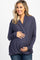 smiling woman wearing a navy blue long sleeve draped wrap top and dark wash jeans