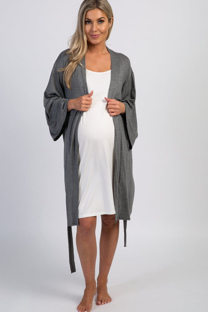 woman wearing a gray maternity robe over a white maternity dress and showing her baby bump