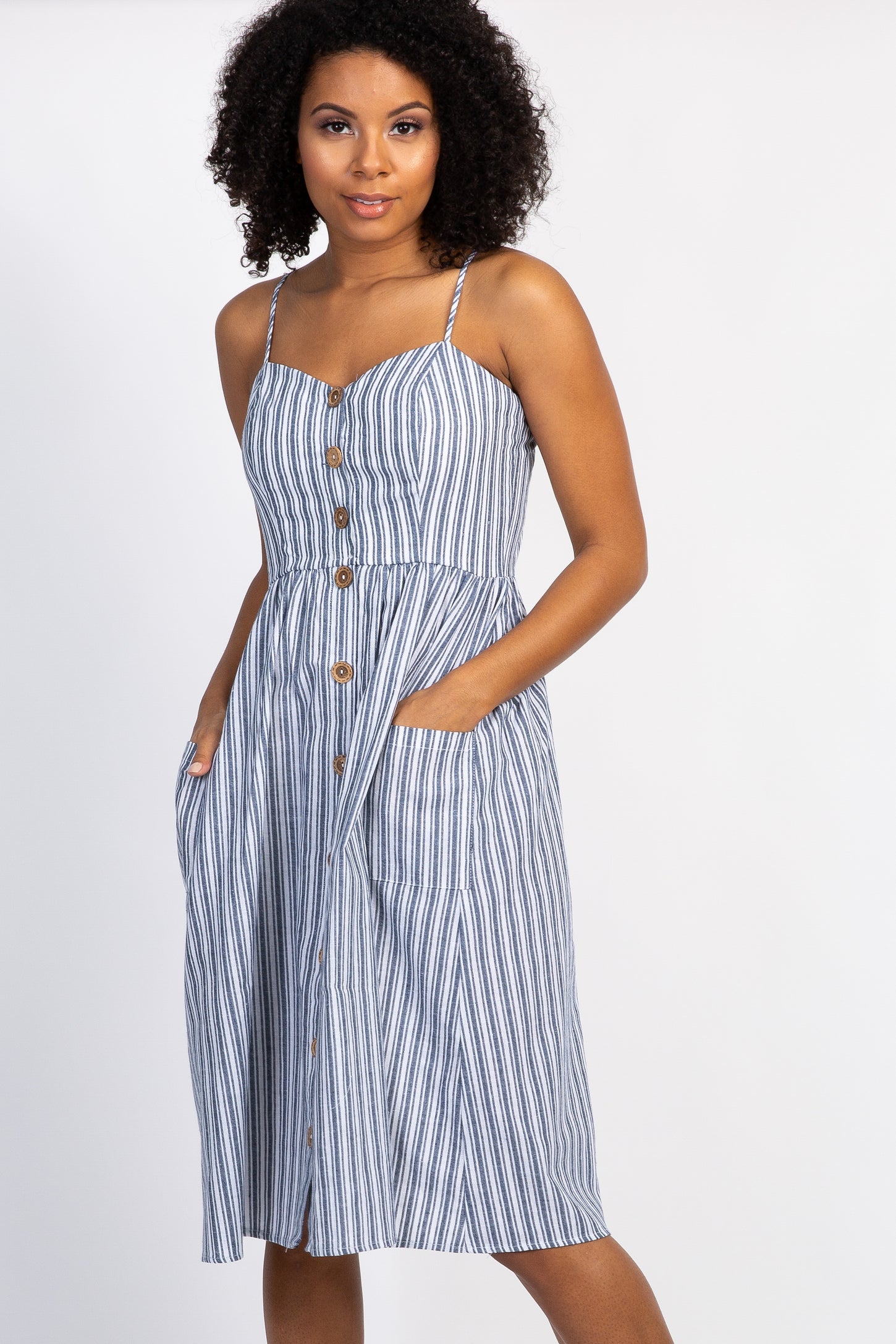 woman wearing a blue and white striped midi dress with buttons and pockets against a white background