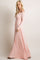 woman wearing a soft pink off-the-shoulder maxi dress with long sleeves and a flowing silhouette