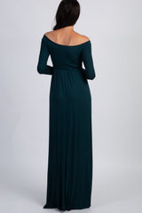 woman wearing a long sleeve off-the-shoulder dark teal maxi dress, seen from the back