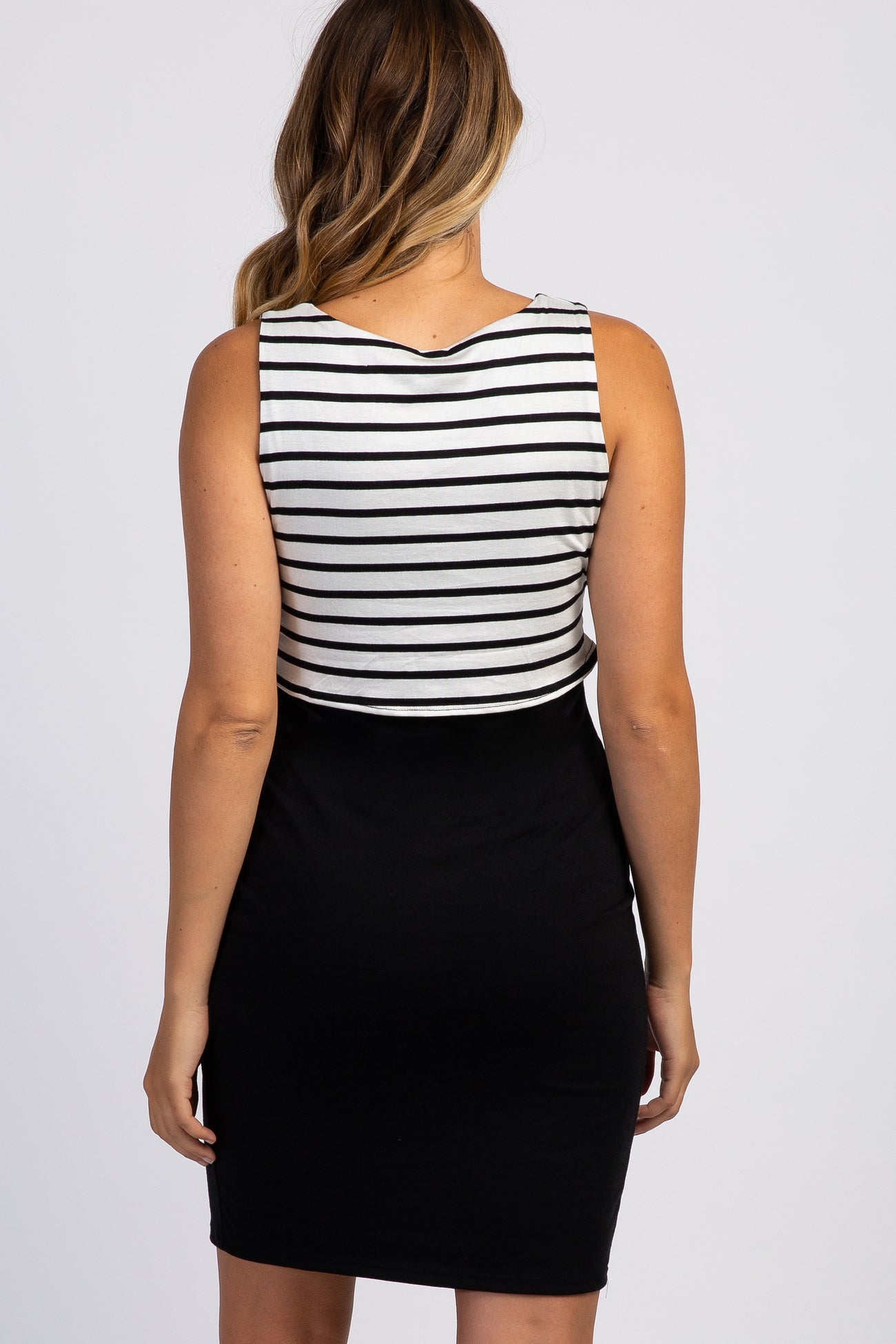 woman wearing a black and white striped maternity dress with a form-fitting black skirt
