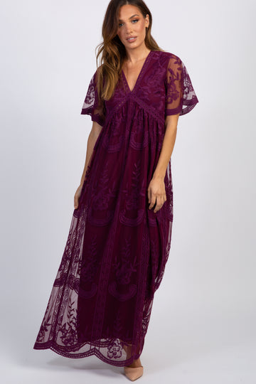 woman wearing a burgundy embroidered maxi dress with short sleeves and a deep v-neckline