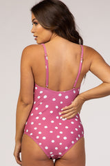 woman wearing a pink polka dot maternity swimsuit with adjustable straps and a flattering cut